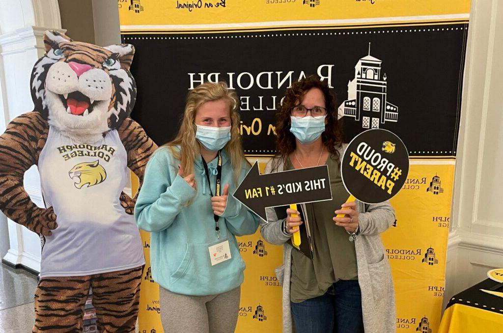 A mother and student pose for a selfie at an event on campus