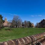 Photo of front campus, with the Red Brick Wall, the lawn, and Main Hall all visible