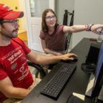 Reese Cooper '25 and professor Timothy Patrick sit in front of a computer, analyzing data